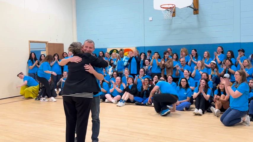 Video of man receiving his award for Employee of the Month; fellow staff members cheer him on in congratulations.