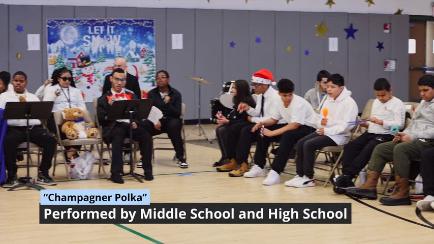 a crowd of students sing and play in a gymnasium 