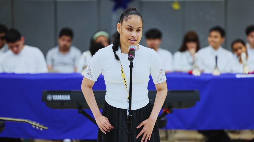 A girl sings in the middle of a gymnasium 