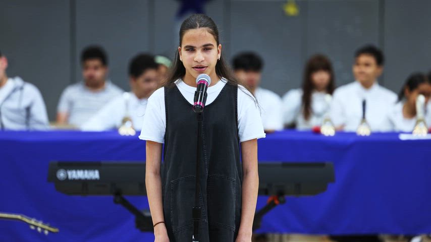 a girl sings into a microphone 