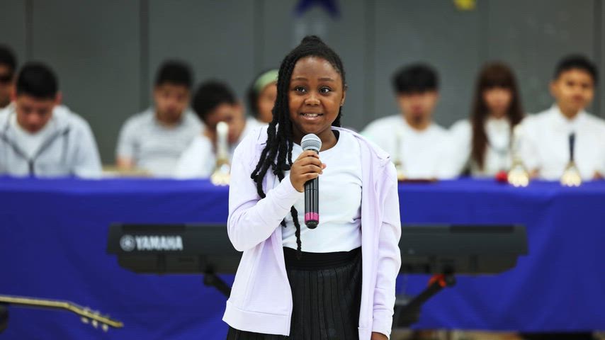 a girl sings at a microphone 