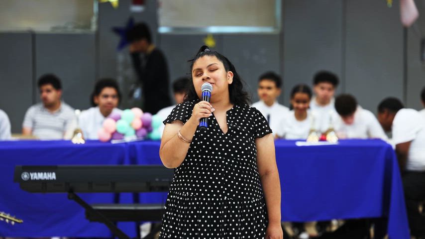 a girl sings into a microphone 