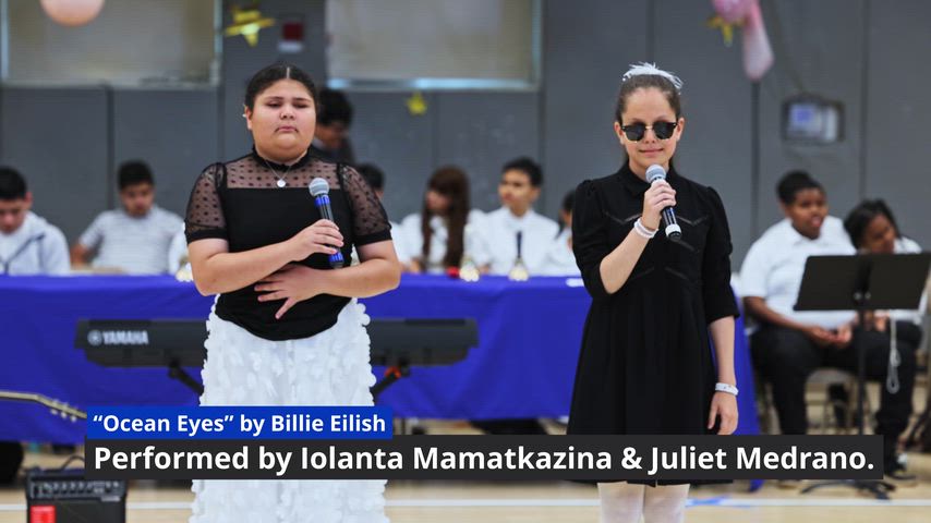 two girls are singing in front of a microphone 