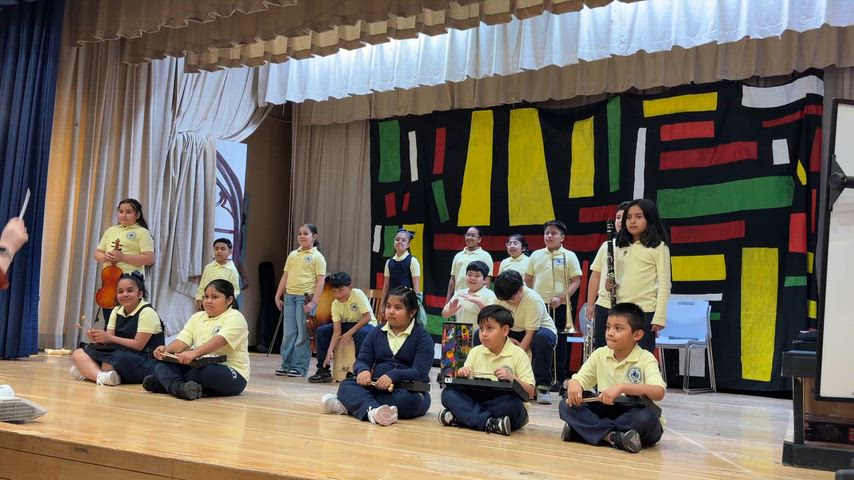 Students performing with instruments on stage.