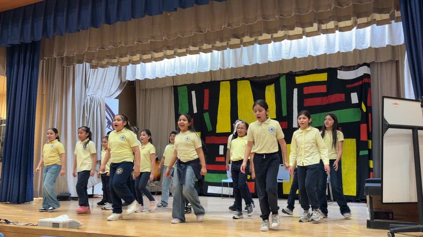 Students singing and dancing on stage.
