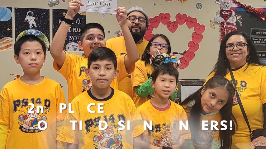 students wearing their yellow team tshirt competing lego robots compettion