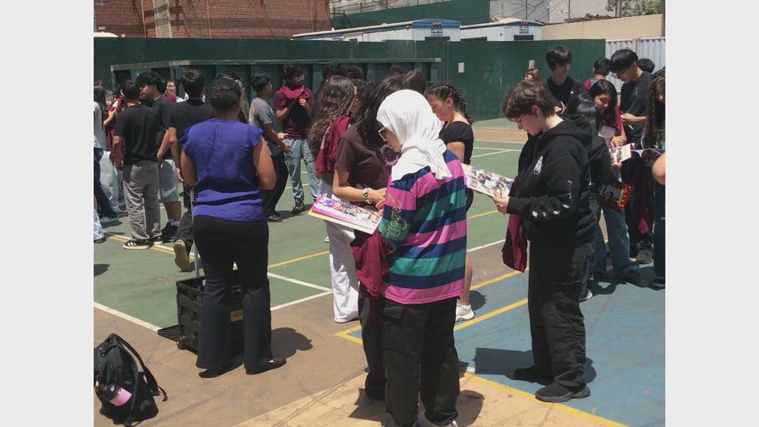 8th Grade students signed each other's yearbooks in the 104 Schoolyard.